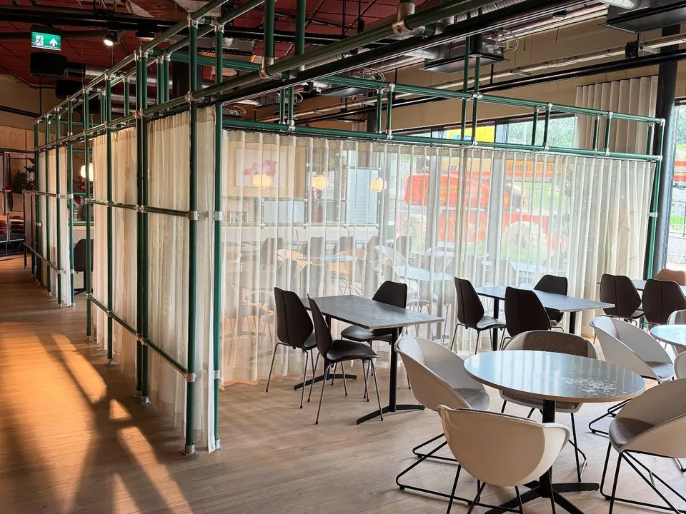 Kontorbygg med transparente gardiner foran glassfasaden