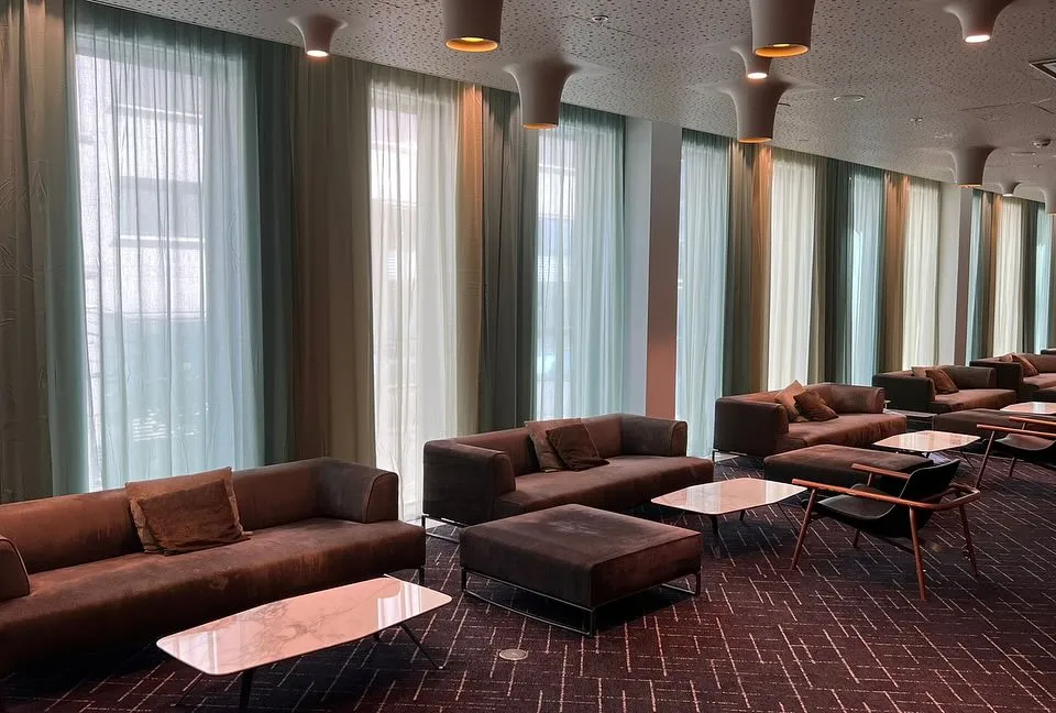 Hotellounge med transparente gardiner fra gulv til tak